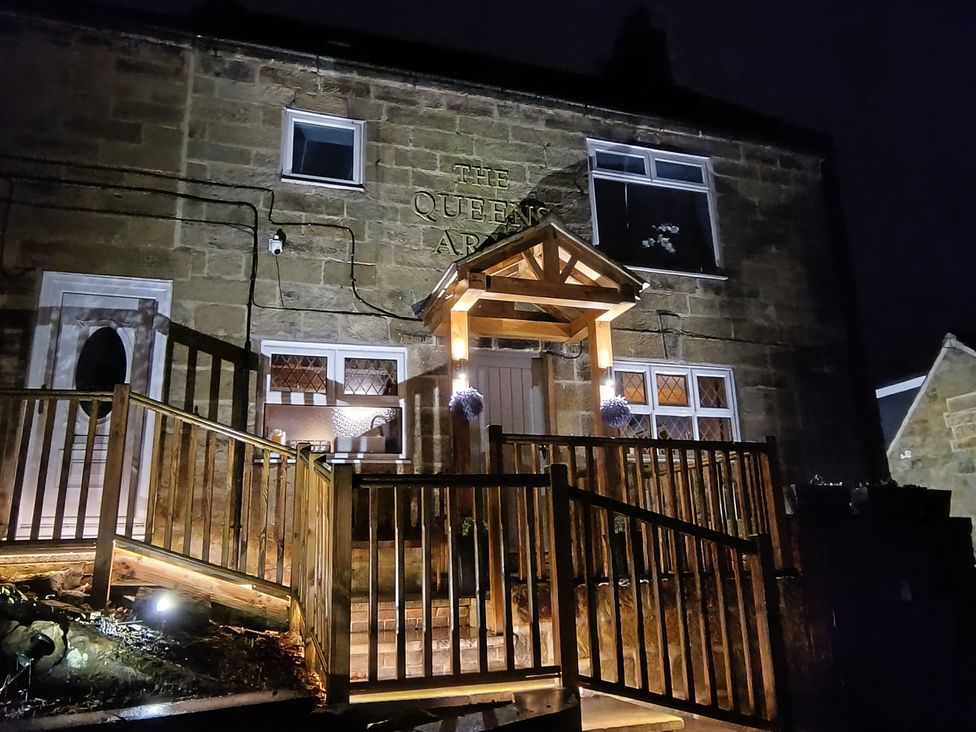 A house exterior with wooden steps and a sign at Cliffe Cottage in Brotton, North Yorkshire