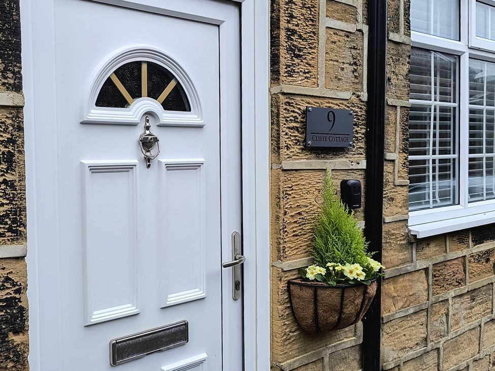 A front door with a flower pot at Cliffe Cottage in Brotton, North Yorkshire