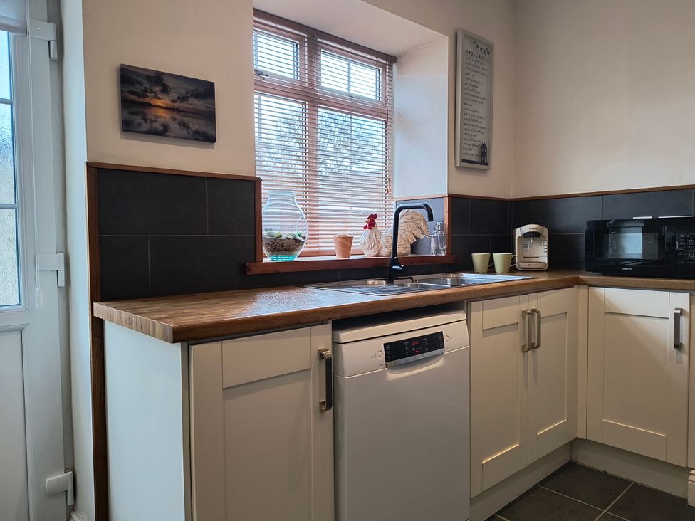 A kitchen with a sink and dishwasher at Cliffe Cottage in Brotton, North Yorkshire
