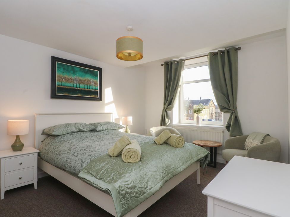 A bedroom with a large bed and bedside table at 32A Bank Street, Rossendale