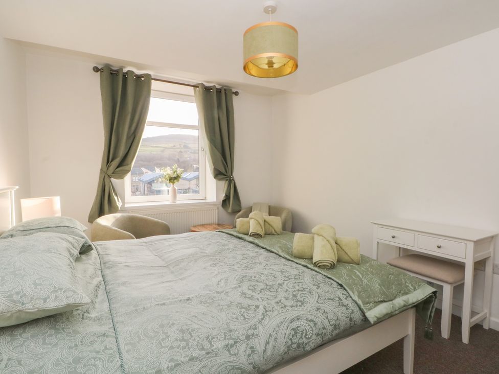 A bedroom with a bed, desk and window at 32A Bank Street in Rossendale