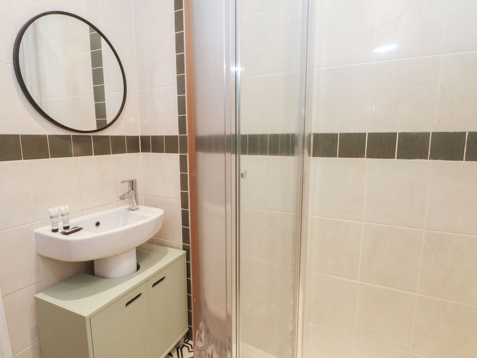 A bathroom with a sink and shower at 32A Bank Street in Rossendale