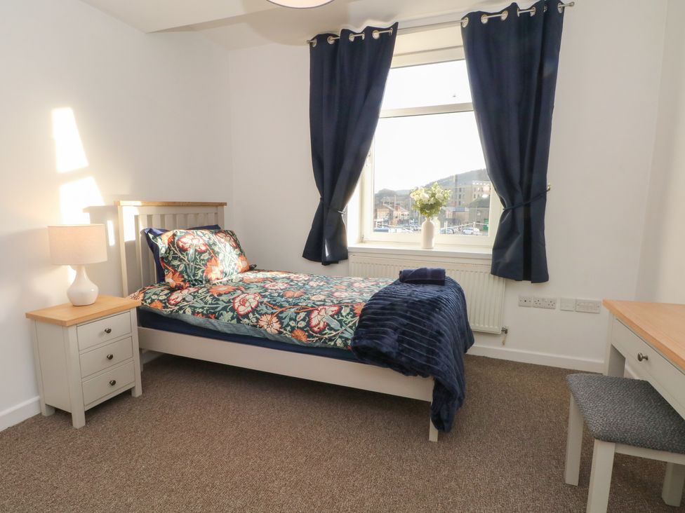 A bedroom with a bed, desk, and window at 32A Bank Street in Rossendale