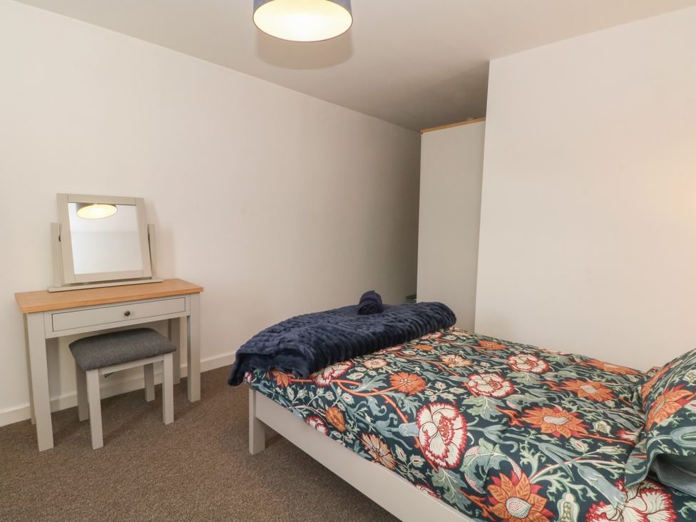 A bedroom with a bed and dressing table at 32A Bank Street Rossendale