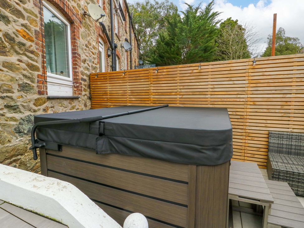 An outdoor area with a hot tub and patio furniture at 4 Brynteg Terrace Menai Bridge