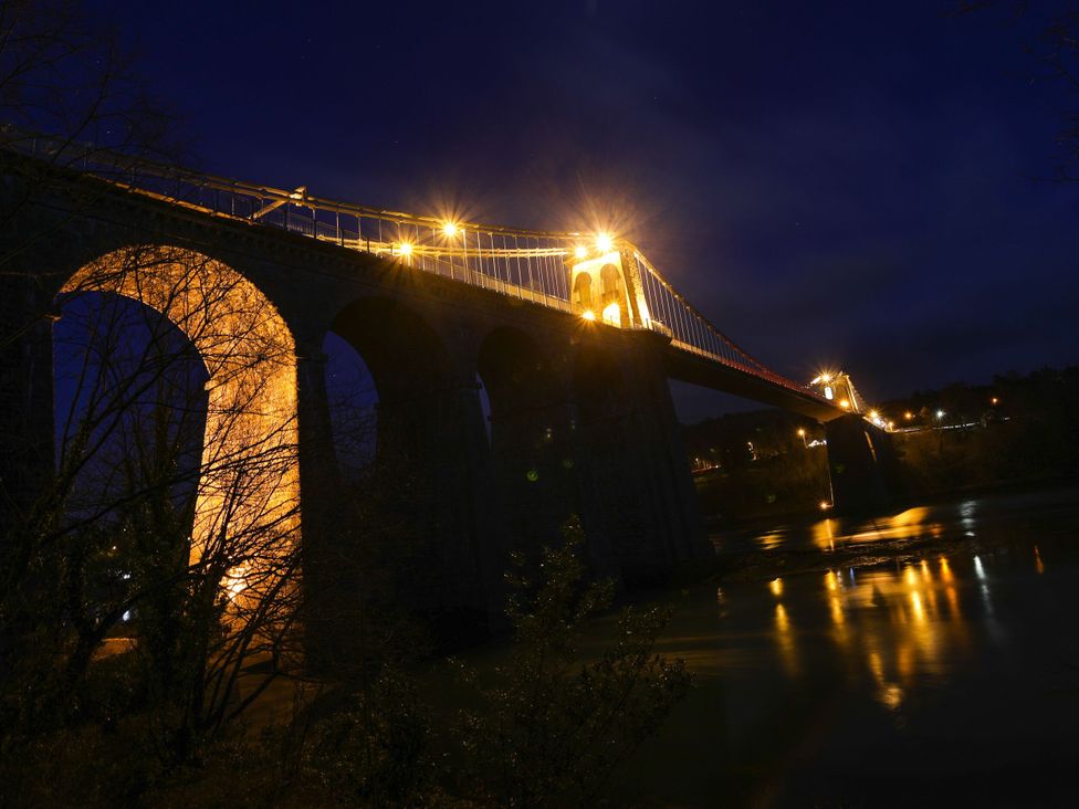 A bridge with lights over a river at 4 Brynteg Terrace Menai Bridge