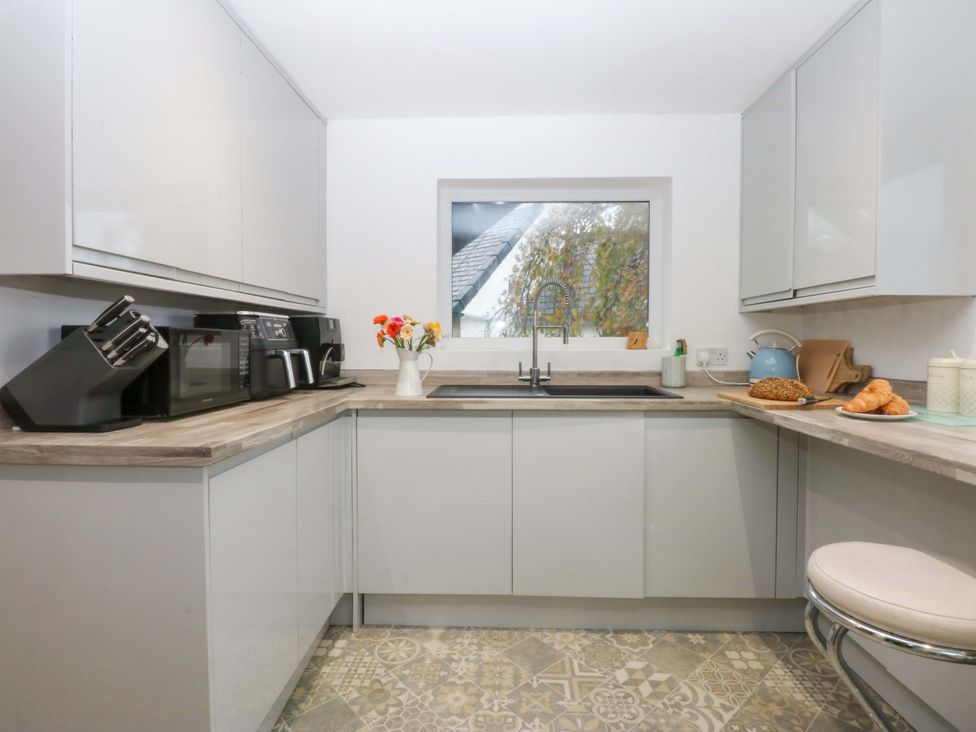 A kitchen with a sink and appliances at 4 Brynteg Terrace Menai Bridge