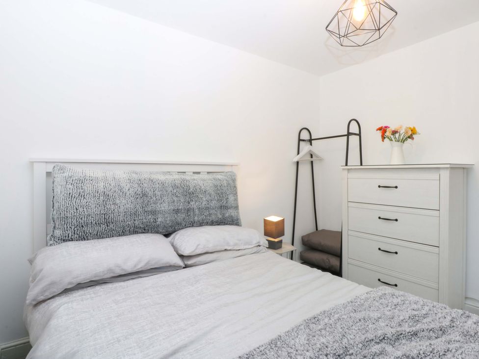 A bedroom with a bed and dresser at 4 Brynteg Terrace in Menai Bridge