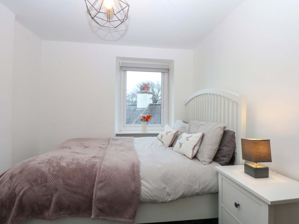 A bedroom with a bed and a window at 4 Brynteg Terrace in Menai Bridge