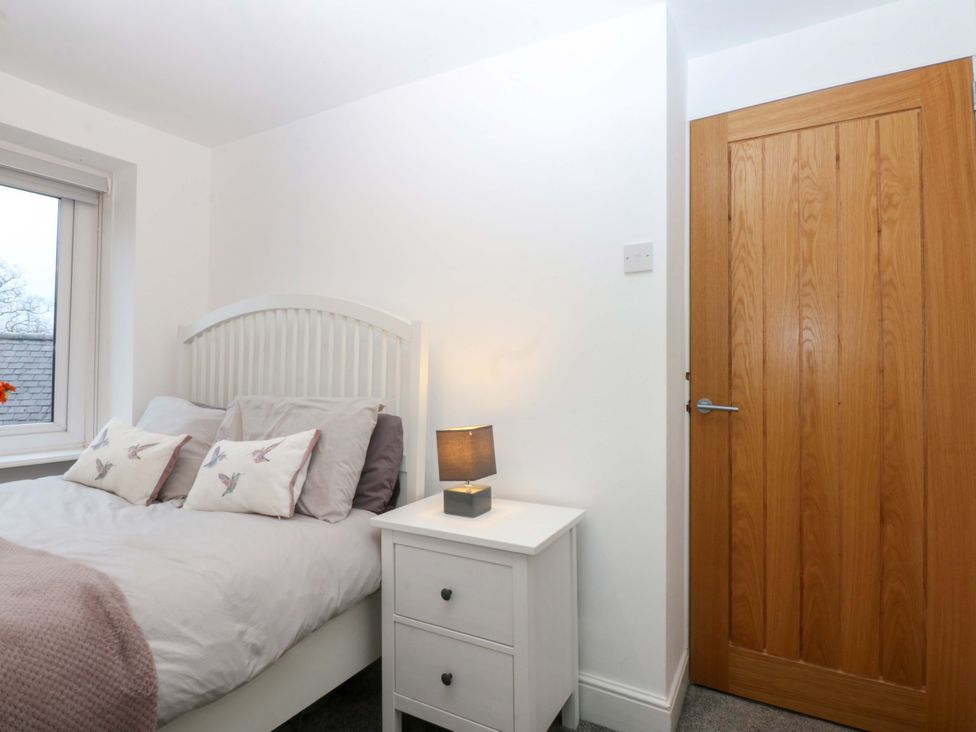 A bedroom with a bed and nightstand at 4 Brynteg Terrace in Menai Bridge
