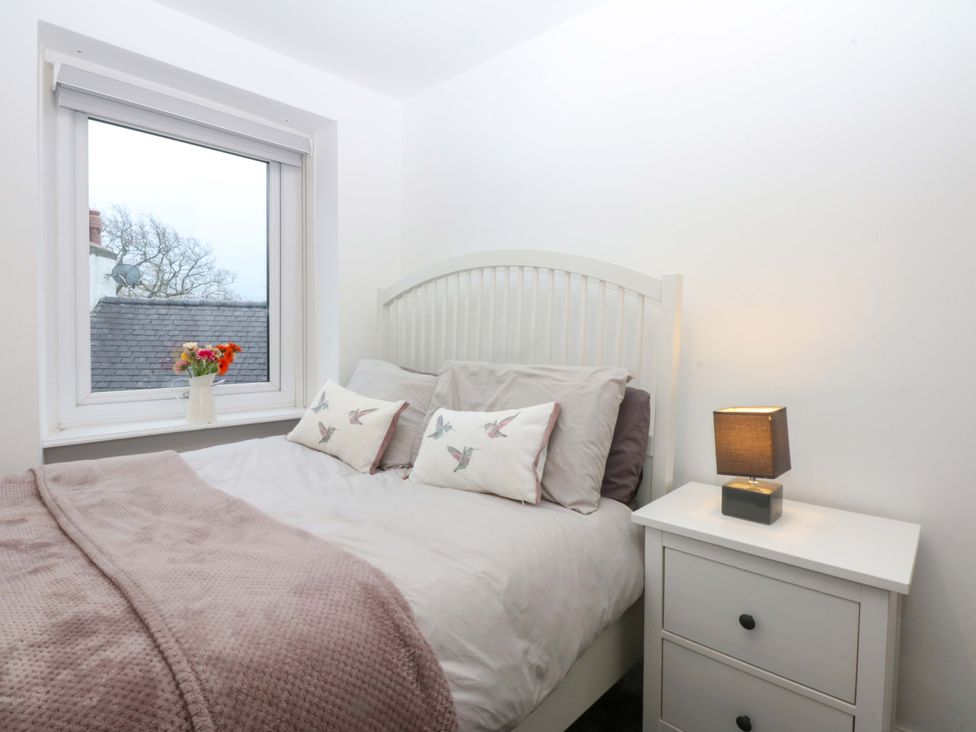 A bedroom with a bed and a window at 4 Brynteg Terrace Menai Bridge
