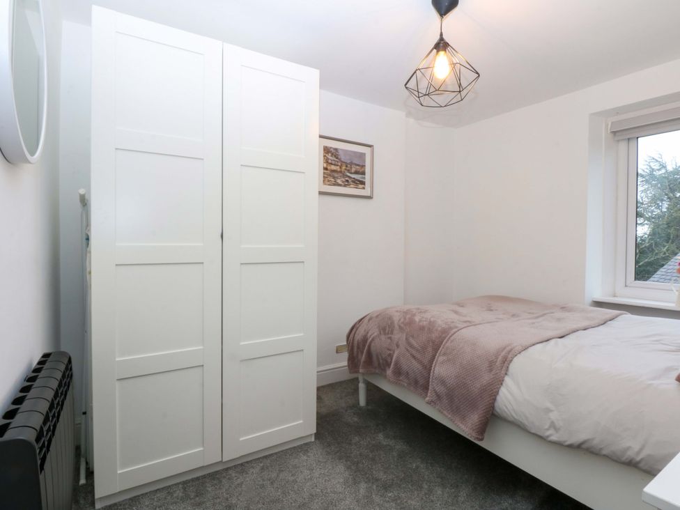 A bedroom with a bed and wardrobe at 4 Brynteg Terrace in Menai Bridge