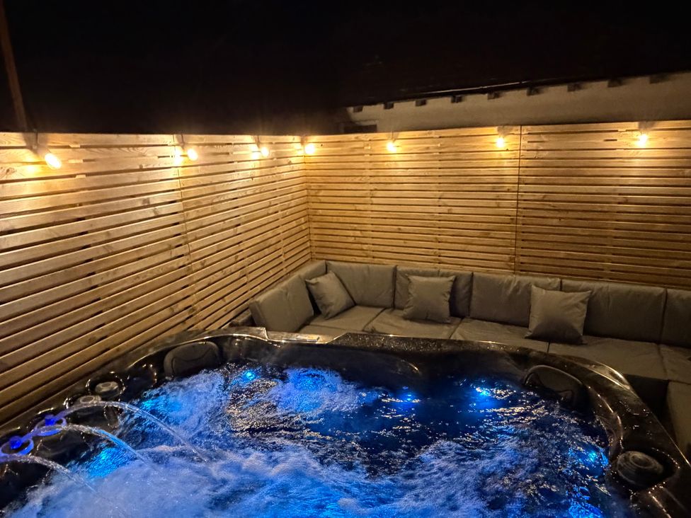 An outdoor area with a hot tub and seating at 4 Brynteg Terrace Menai Bridge