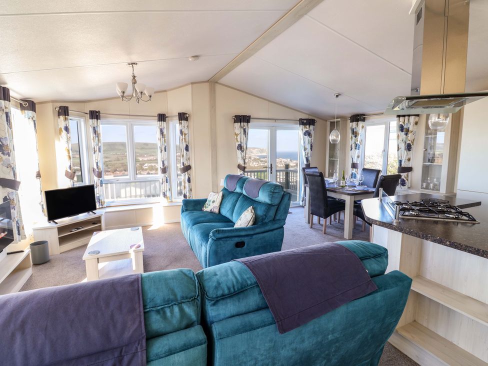 A living room with a sofa and dining area at 91 Swanage Coastal Park in Swanage