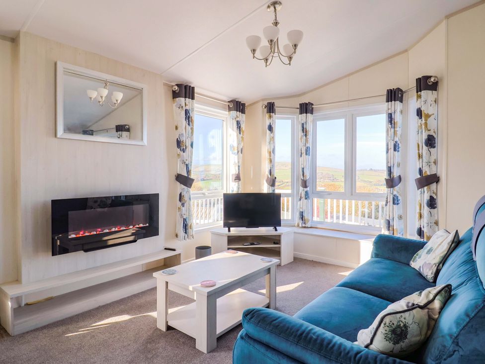 A living room with sofa and television at 91 Swanage Coastal Park in Swanage