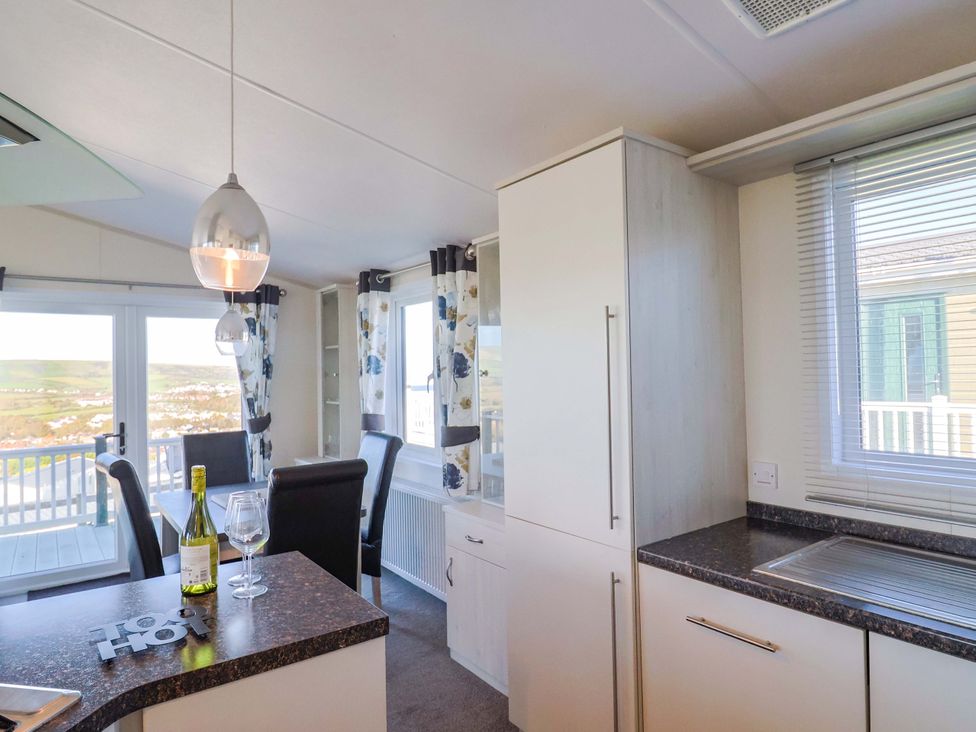 A kitchen with wine bottle and glasses at 91 Swanage Coastal Park in Swanage