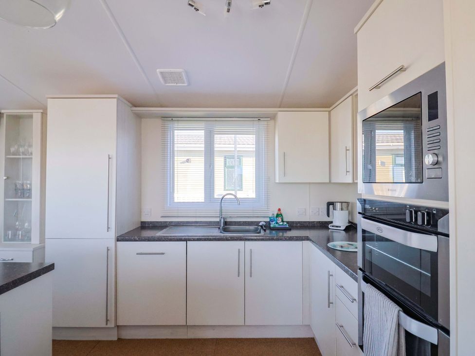 A kitchen with cabinets, sink, and appliances at 91 Swanage Coastal Park, Swanage