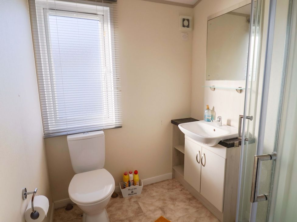 A bathroom with a shower, sink, and toilet at 91 Swanage Coastal Park in Swanage