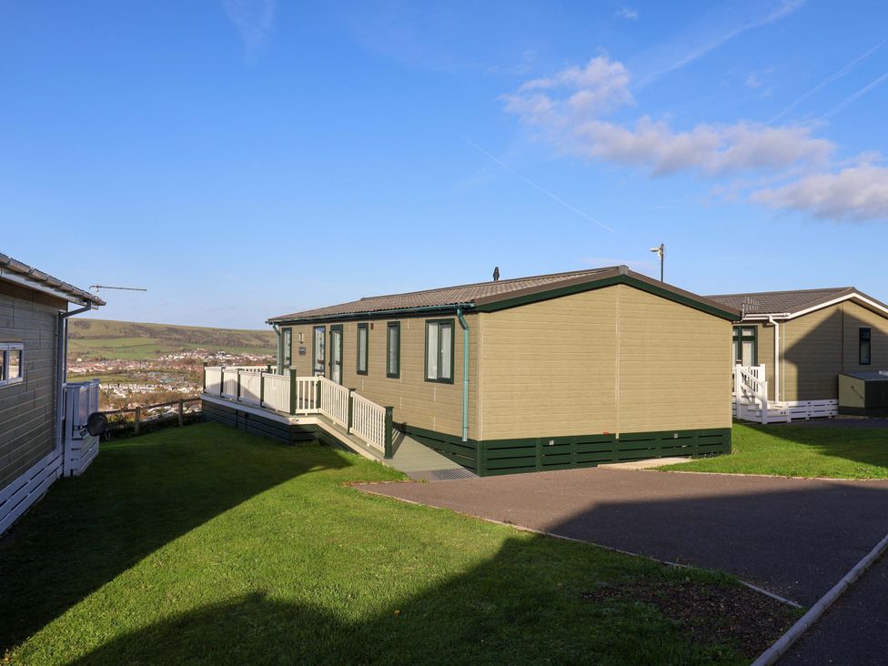A mobile home with a deck and pathway at 91 Swanage Coastal Park in Swanage