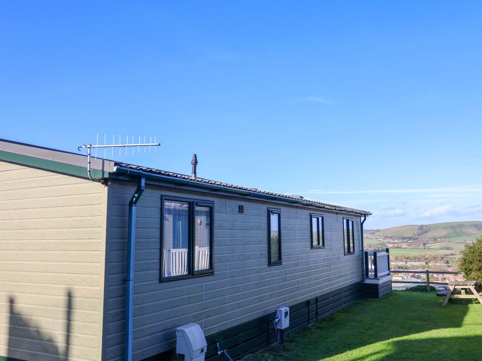 A mobile home with windows and an antenna in an outdoor area at 91 Swanage Coastal Park in Swanage