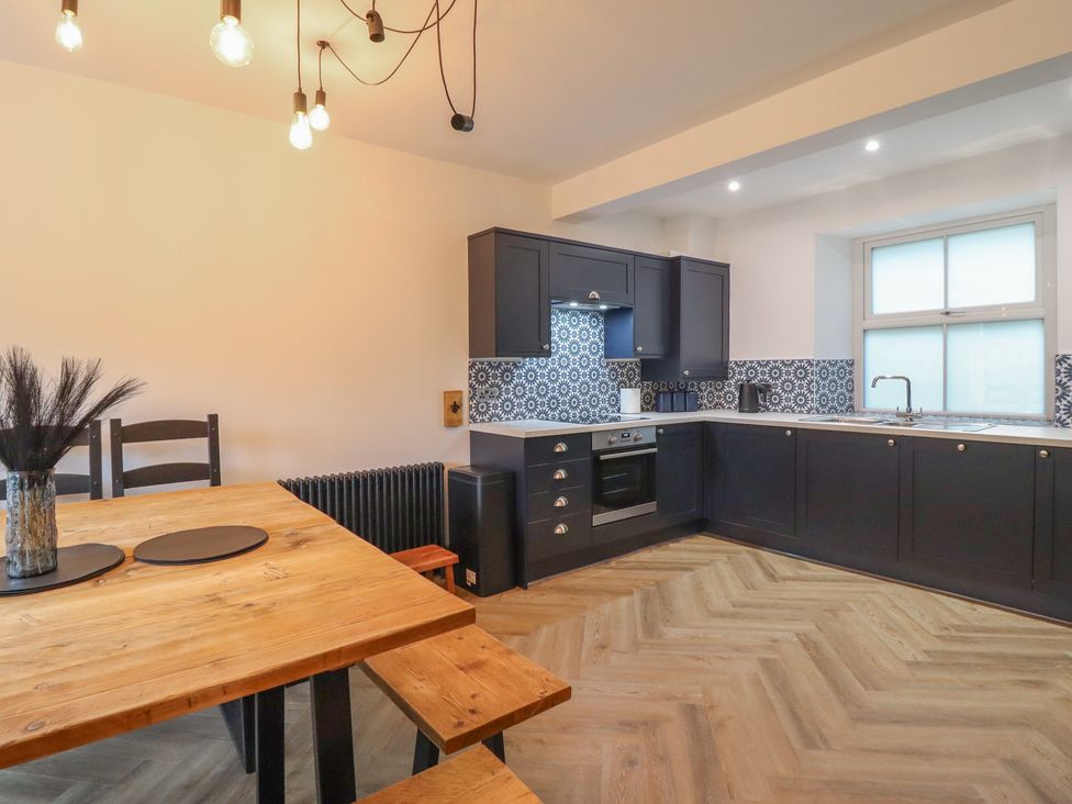 A kitchen with a dining table and chairs at Green Bank in Betws-Y-Coed