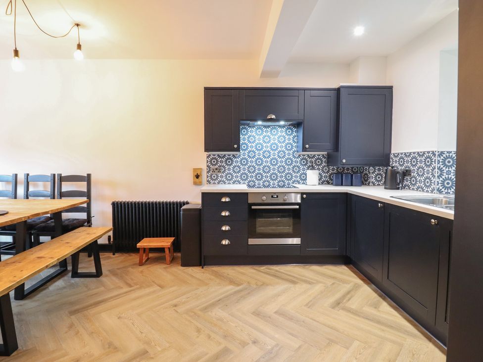 A kitchen with cabinets and appliances at Green Bank in Betws-Y-Coed