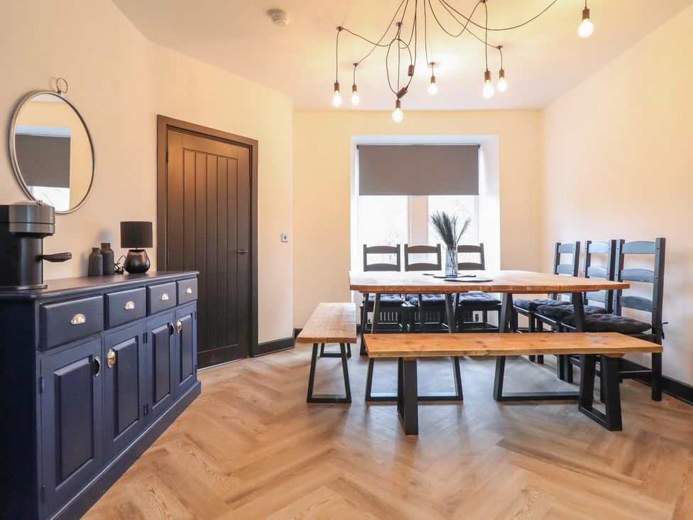 A dining room with a table and benches at Green Bank in Betws-Y-Coed