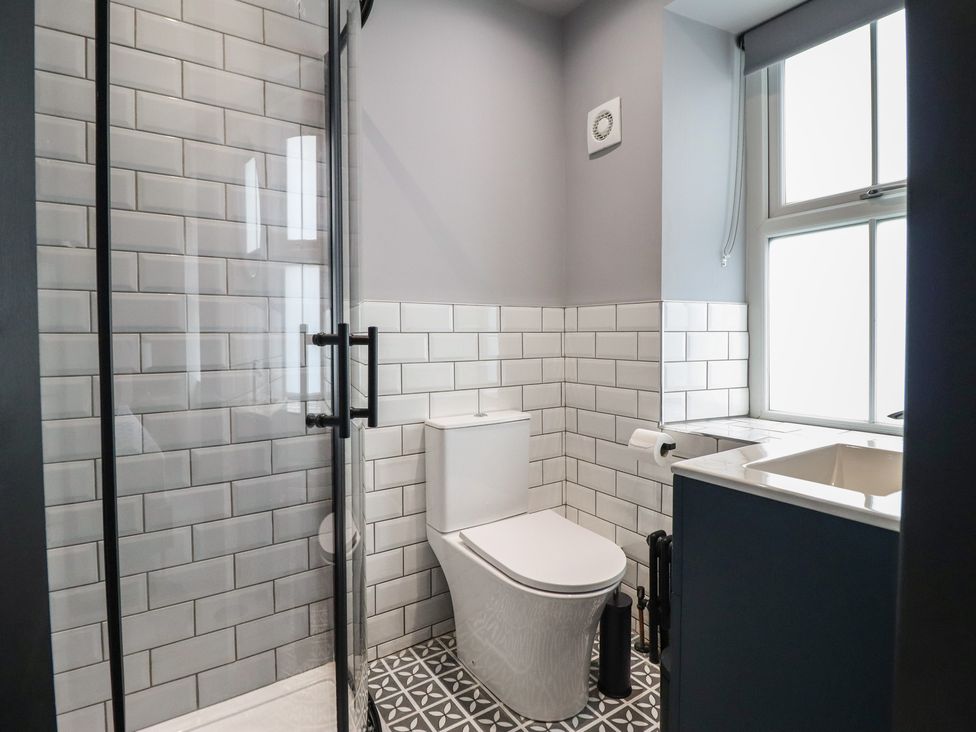 A bathroom with a shower, toilet, and sink at Green Bank in Betws-Y-Coed