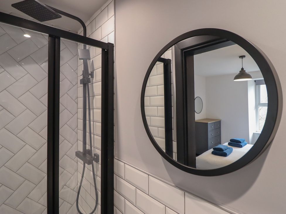 A bathroom with a shower and a mirror at Green Bank in Betws-Y-Coed