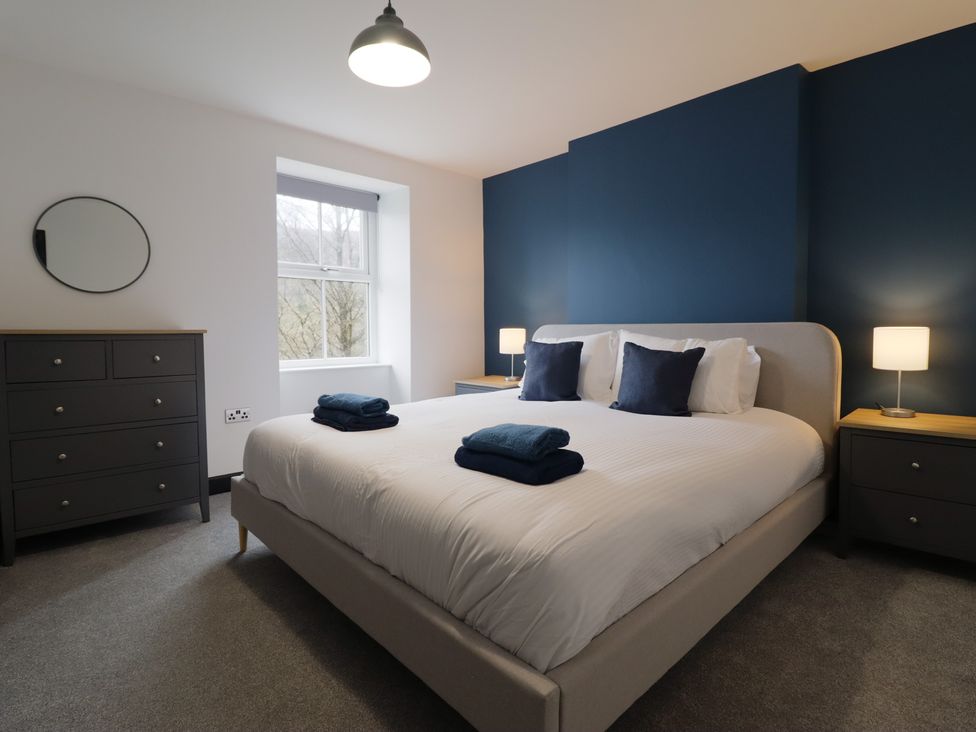 A bedroom with a bed and nightstands at Green Bank in Betws-Y-Coed