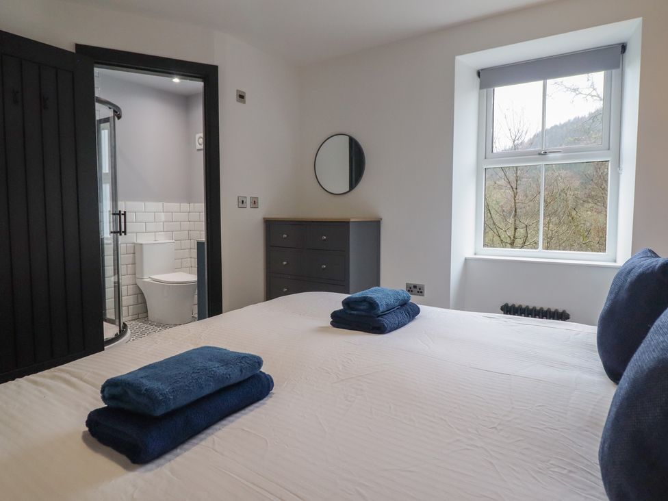 A bedroom with a bed and towels on it at Green Bank in Betws-Y-Coed