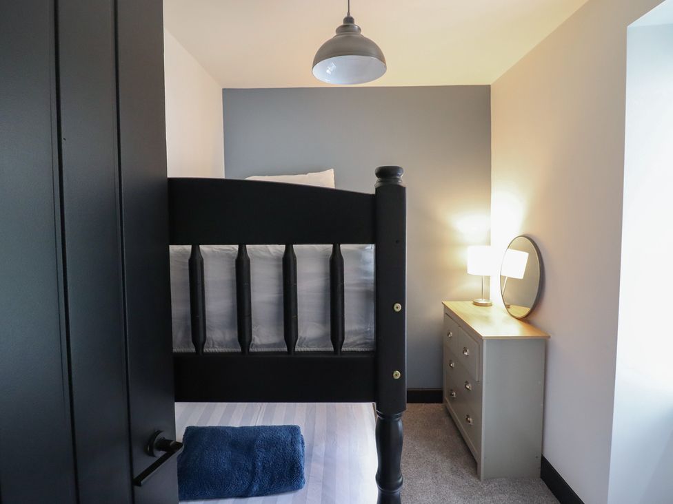 A bedroom with a bunk bed and a dresser at Green Bank in Betws-Y-Coed