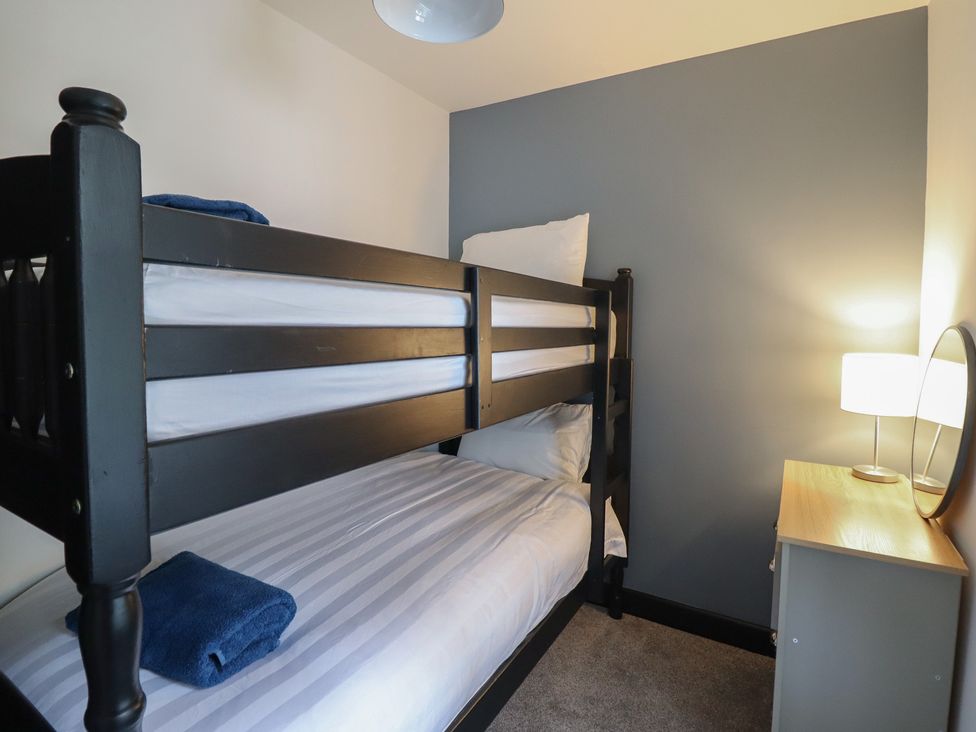 A bedroom with a bunk bed and lamp at Green Bank in Betws-Y-Coed