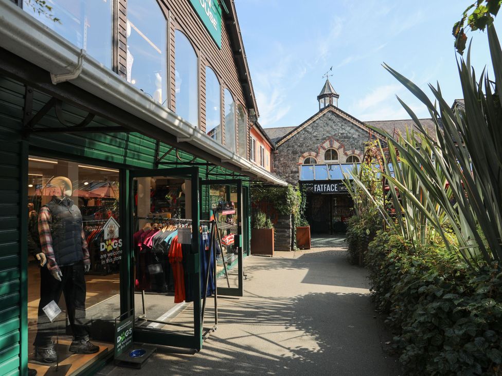 A shopping pathway with storefronts and mannequins at Green Bank in Betws-Y-Coed