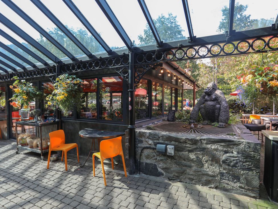 An outdoor sitting area with a table and orange chairs at Green Bank in Betws-Y-Coed
