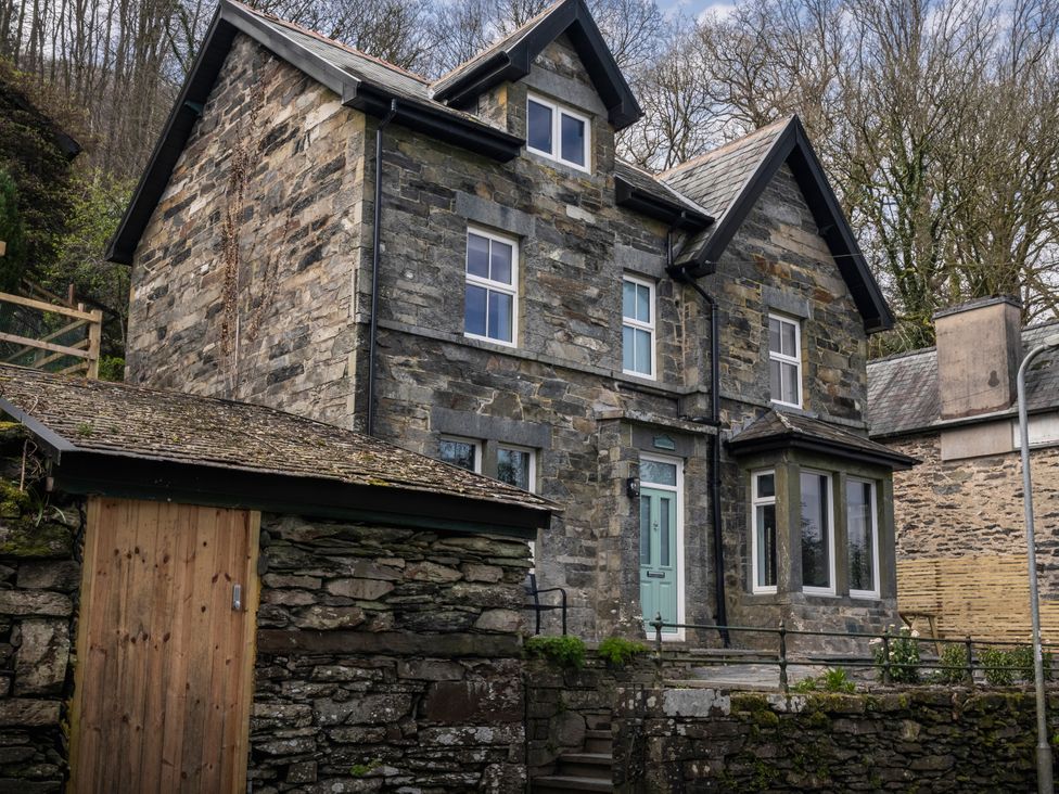 An outdoor view of a stone house with a garden at Green Bank in Betws-Y-Coed