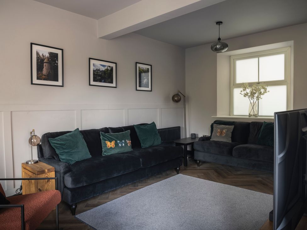 A living room with a sofa and armchair at Green Bank in Betws-Y-Coed