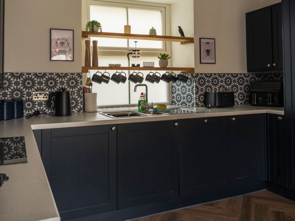 A kitchen with a sink and shelves at Green Bank in Betws-Y-Coed
