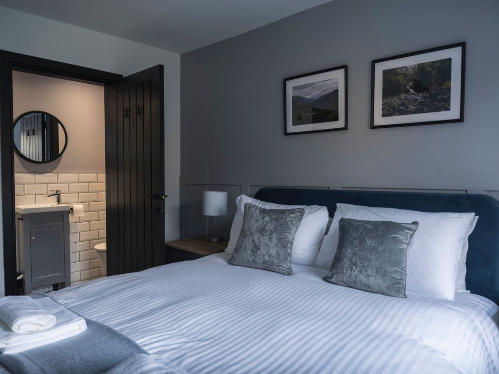 A bedroom with a bed and attached bathroom at Green Bank in Betws-Y-Coed