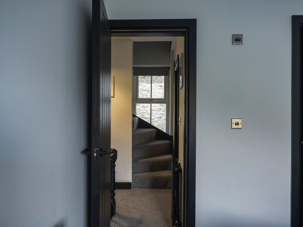 A hallway with stairs and a window at Green Bank in Betws-Y-Coed