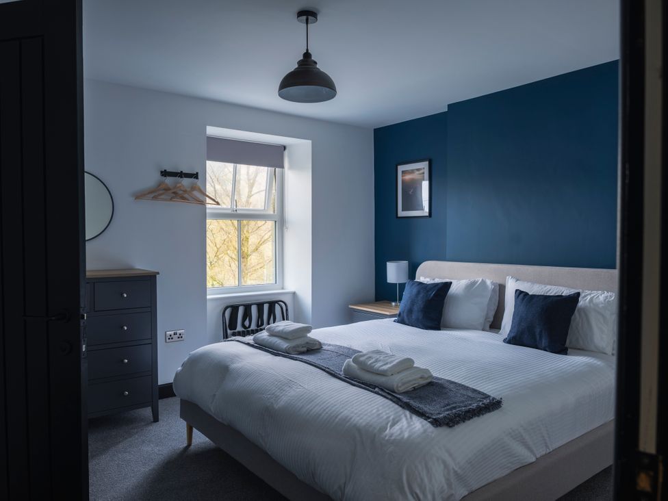 A bedroom with a double bed and bedside table at Green Bank in Betws-Y-Coed