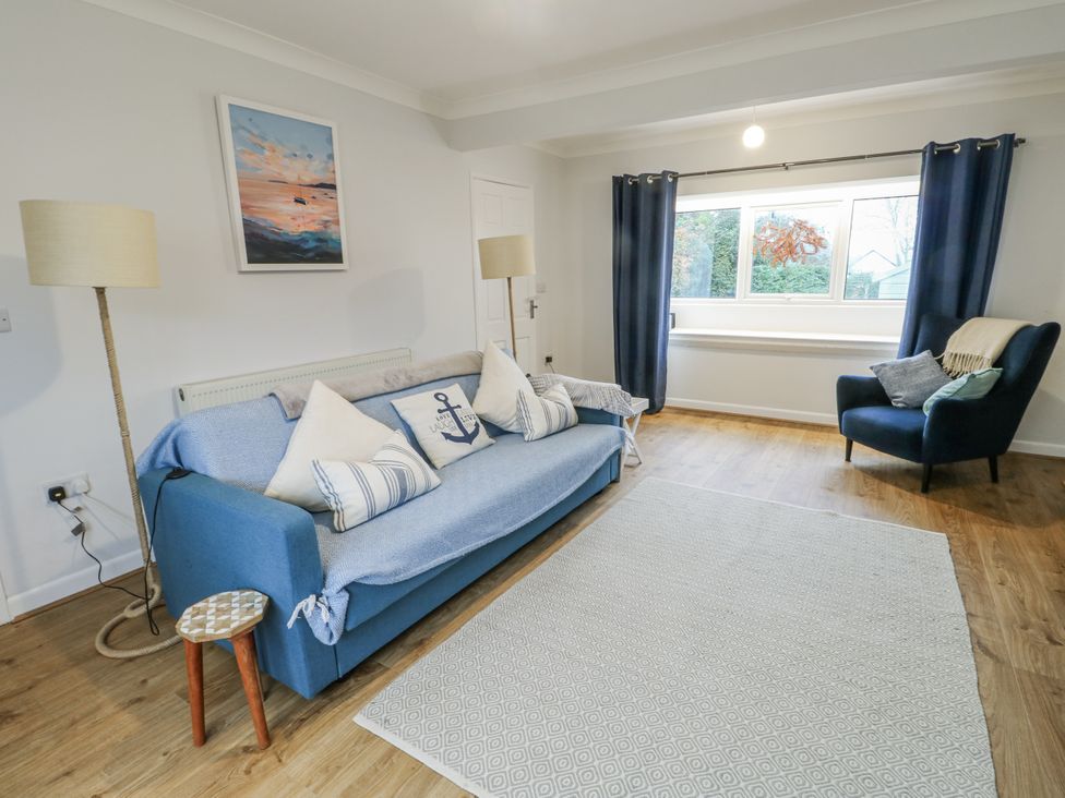 A living room with a sofa and armchair at 16 Ffordd Meigan Beaumaris