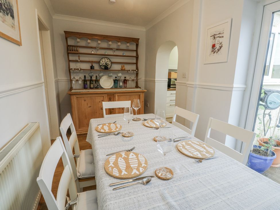 A dining room with a table set for dinner at 16 Ffordd Meigan in Beaumaris