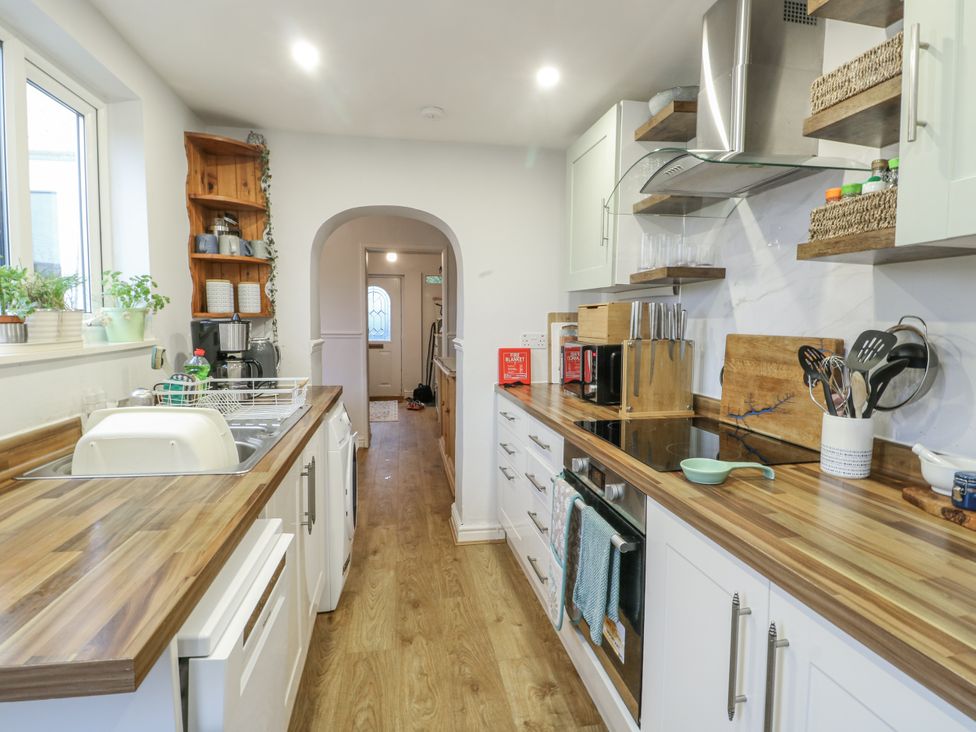 A kitchen with cabinets and appliances at 16 Ffordd Meigan Beaumaris