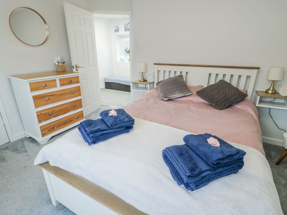 A bedroom with a double bed and dresser at 16 Ffordd Meigan Beaumaris
