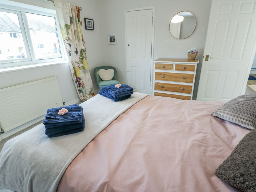 A bedroom with towels on the bed at 16 Ffordd Meigan in Beaumaris