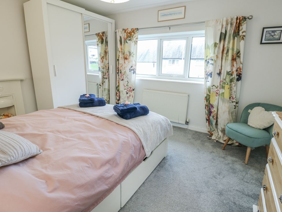 A bedroom with a double bed and wardrobe at 16 Ffordd Meigan Beaumaris