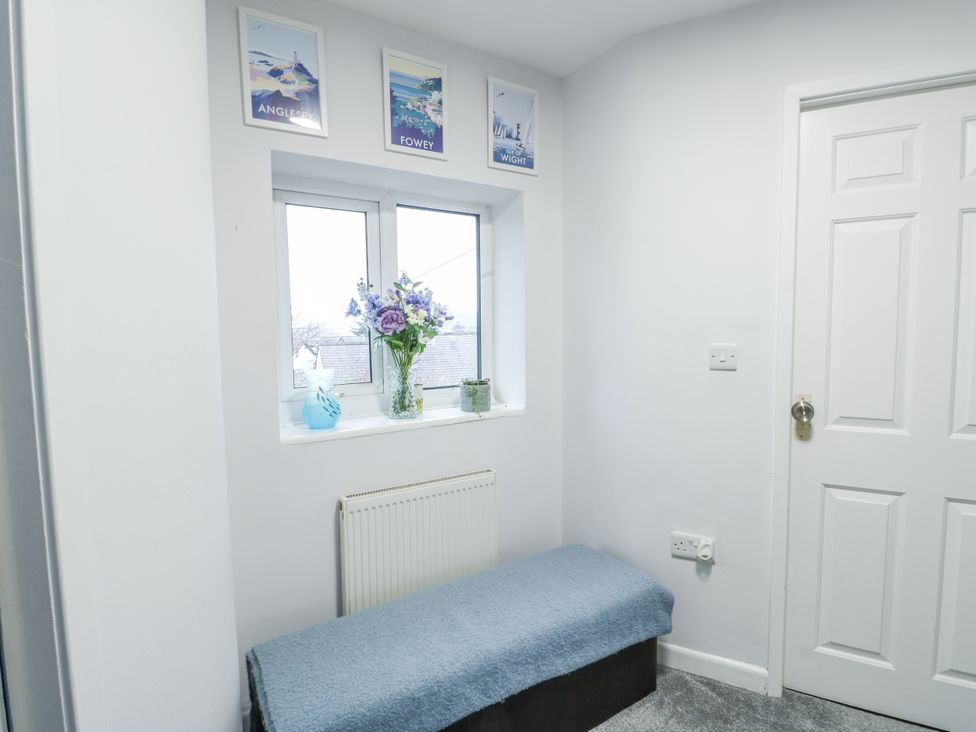 A hallway with a bench and flower vase at 16 Ffordd Meigan Beaumaris