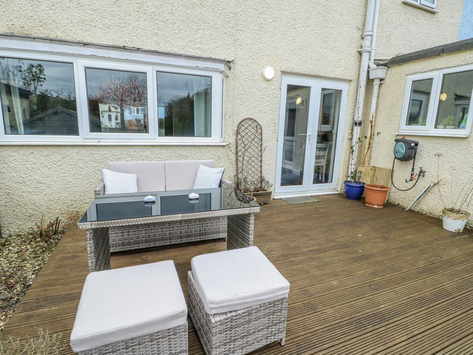An outdoor patio with a sofa and table at 16 Ffordd Meigan Beaumaris