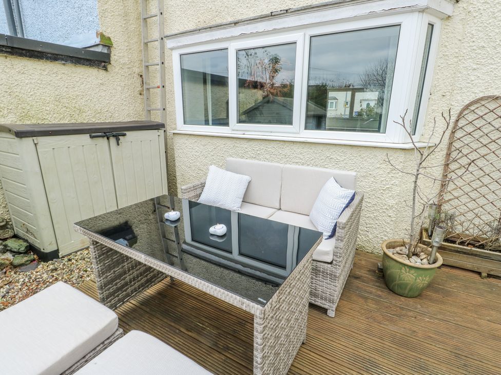 An outdoor seating area with a table and sofa at 16 Ffordd Meigan in Beaumaris